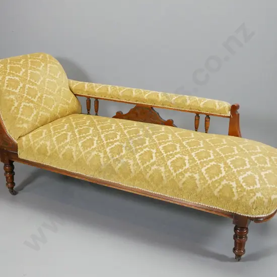 Edwardian chaise longue w/ nouveau style carved detail, on casters, turned spindles and legs, covered in