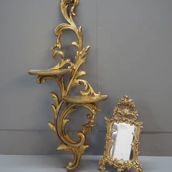 gilt finish cast metal items - mirror in ornate frame and a 2-tier wall shelf, some loss of finish H-650 W-300