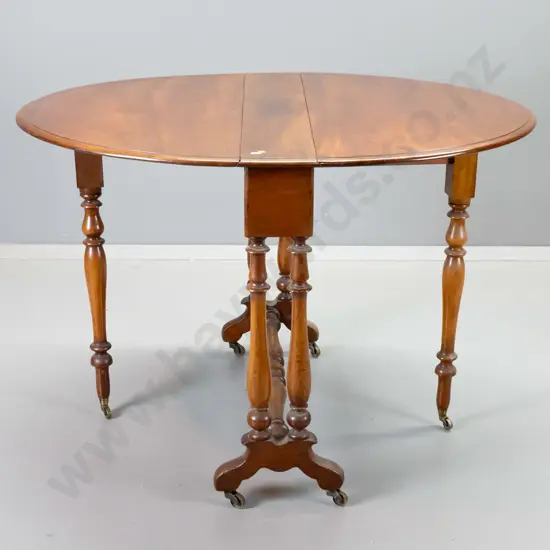 antique mahogany oval drop-side table with original metal casters, stretcher base, polish uneven on top