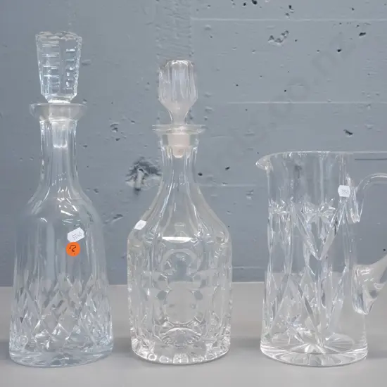 3 cut crystal items - 2 stoppered decanters and a large jug, no maker's marks. Larger decanter is H-330