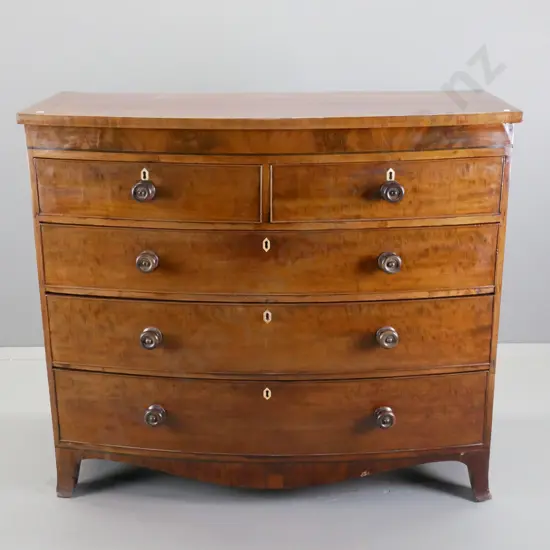 antique mahogany bow-front 5-drawer chest with flame veneer fronts, bone or ivory escutcheons - some chips to veneer and