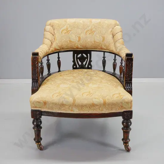Edwardian dark-stained timber tub chair with turned spindles, porcelain casters, gold patterned brocade w/corded detail