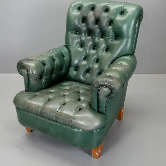 vintage green leather rolled arm deep-button club style armchair on tapered wooden legs, metal studded decoration