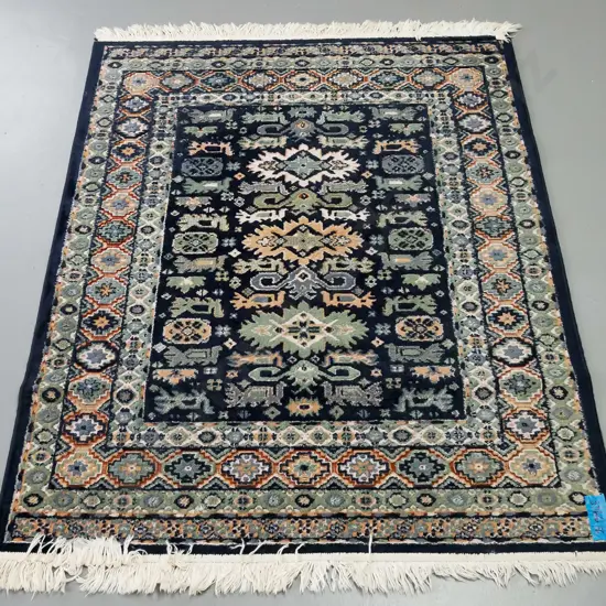 rug in green and blue ground, central medallion of geometric design, multiple geometric borders