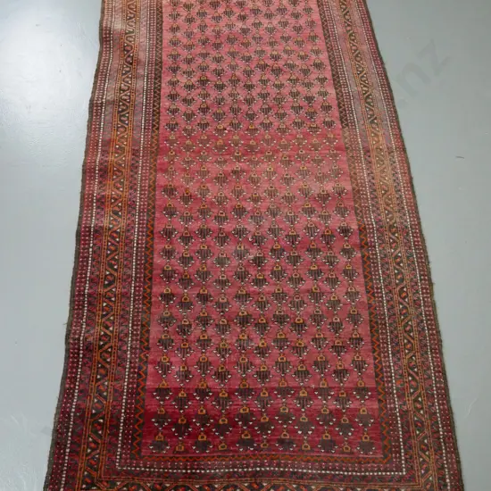 hand-knotted wool floor rug - red ground, orange and browns, geometric patterns - some fading and wear L-1950 W-1040