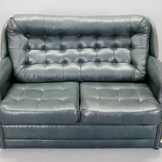 dark green leather upholstered deep button 2-seater settee with brass studded decoration, loose seat cushions, on