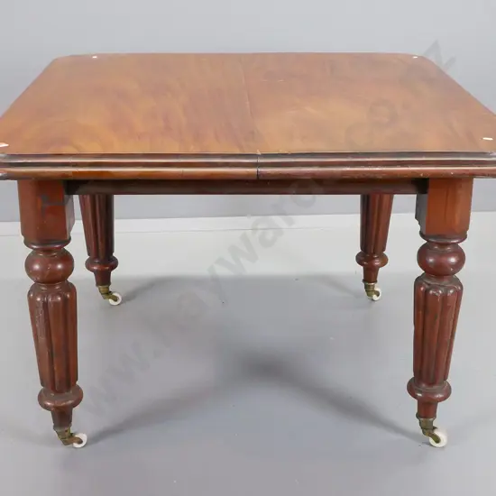 vVctorian mahogany wind-out dining table with fluted turned legs and white porcelain casters