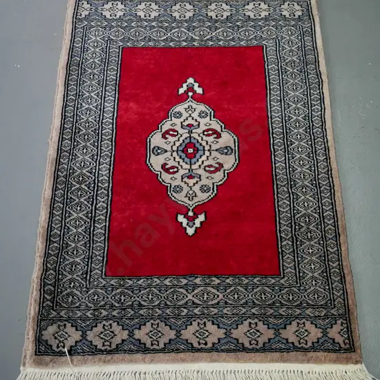 handknotted woollen kashan rug, red ground with central floral motif, multiple blue shaded geometric borders,