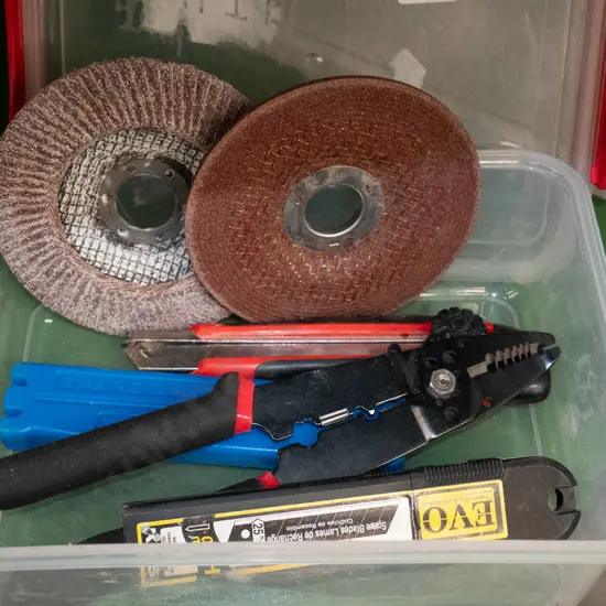 Container, grinder discs, craft knives, wire strippers