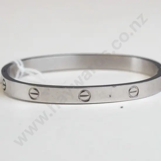 Silver bracelet, circle designs around the edges. Clasp closing. 
