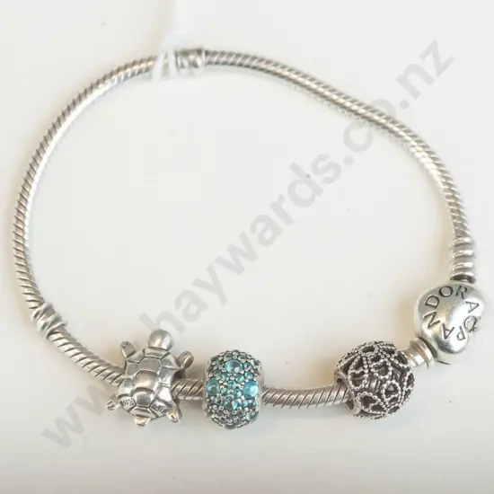 Pandora silver bracelet with four charms.