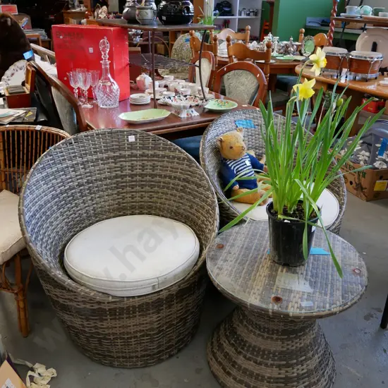 2 woven plastic outdoor tub chairs and cushions and matching glass topped table