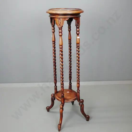 reproduction mahogany plant stand with round top on 4 twisted uprights, lower shelf, 4 scrolling legs, fading to polish.