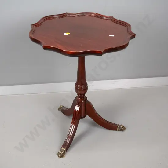 reproduction mahogany wine table with shaped moulded top, turned pedestal w/3 sweeping legs, brass paw feet H500 D400