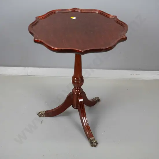 reproduction mahogany wine table with shaped moulded top, turned pedestal w/3 sweeping legs, brass paw feet H500 D400