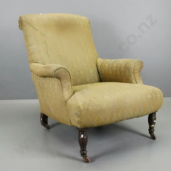 Edwardian rolled-arm fireside chair with turned front legs, porcelain casters, gold & green fabric has wear and needs