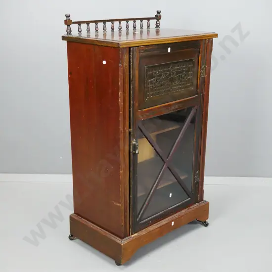 Edwardian music canterbury w/ turned back rail, carved frieze and x-frame glazed door, 3 shelves, drop handle, on plinth