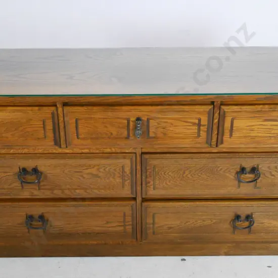 oak 7-drawer chest with mismatched cast metal drop handles and glass top H-670 W-1500 D-430