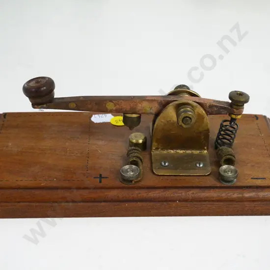 brass and copper telegraph key on wooden base