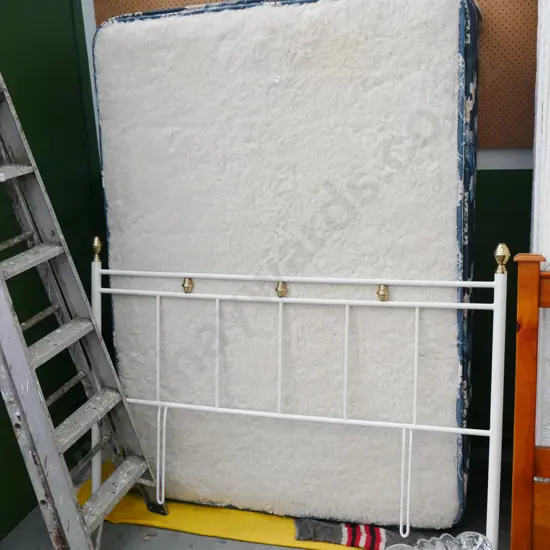 double bed base, mattress with brass and metal headboard and sheepskin topper pad