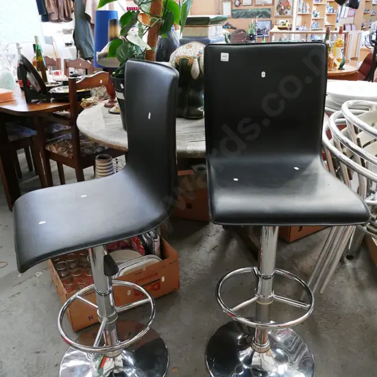 pair of green and black vinyl bar stools