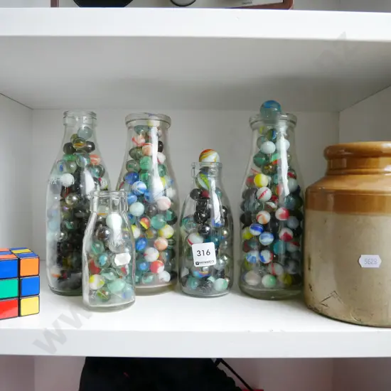 small crock, rubix cube, glass bottles and marbles