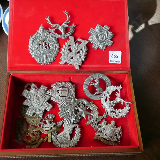 vinyl bound leather box with metal pistol inlay on top, numerous military badges