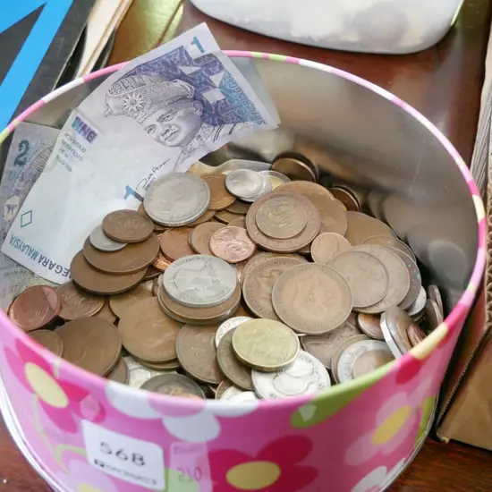 tin of coins and bank notes