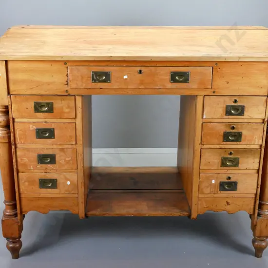 restorer's vintage rimu clerk's desk with sloped top, large top drawer, 8 lower drawers, brass campaign handles, turned