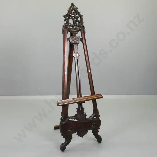 reproduction ornately carved mahogany easel / display stand with pierced crest, scrolling feet, adjustable support bar.