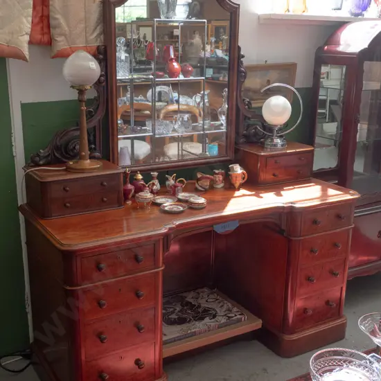 Victorian mahogany mirror-back kneehole dresser with carved foliate supports, 4 upper drawers, 8 lower, all with turned