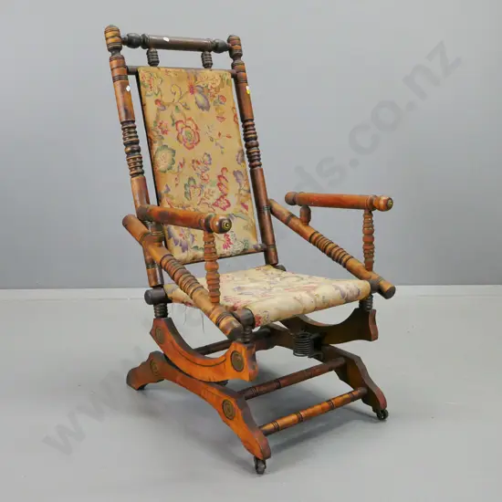 vintage turned beech Dexter rocking chair with brass end caps, metal casters on front legs, borer in rocker