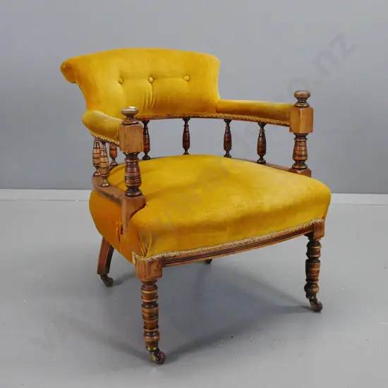 Edwardian beech tub chair with turned legs, uprights and spindle back, on porcelain casters, upholstered in button back