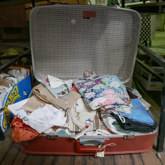suitcase of tablecloths, linen etc