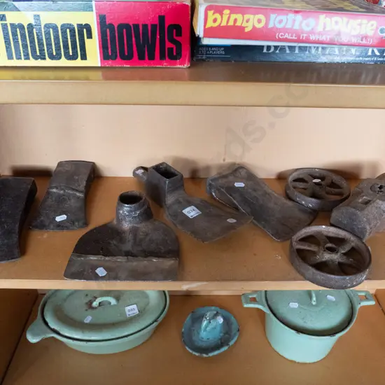 shelf of axe, mattock, hoe and hammer heads and small cast iron wheels
