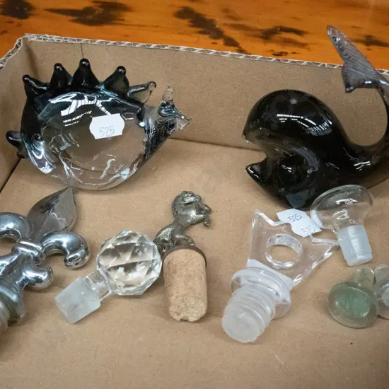 box of art glass ornaments and various bottle stoppers