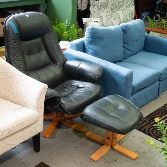 dark green vinyl swivel armchair and stool -some damage to upholstery