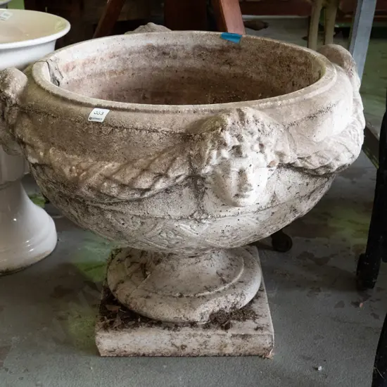 large cast concrete classical style garden urn w/ intertwined swags and female heads, pedestal base on square foot