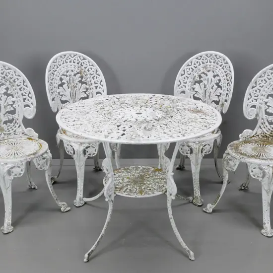 cast alloy white painted patio table and 4 matching chairs, round shelf and umbrella hole in table - overall wear to