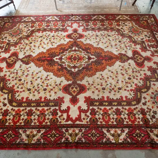 large Feltex New Zealand wool floor rug w/large central medallion, oranges, reds, brown and cream - some wear and stains