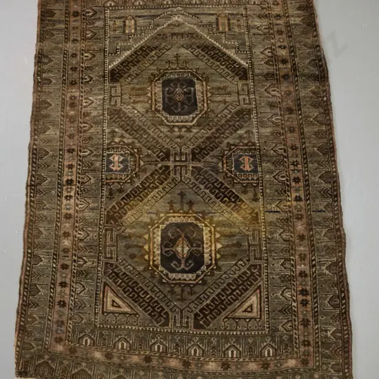 small Persian style hand knotted wool prayer rug - earth tones. Colours faded, fringe worn on both ends, some staining