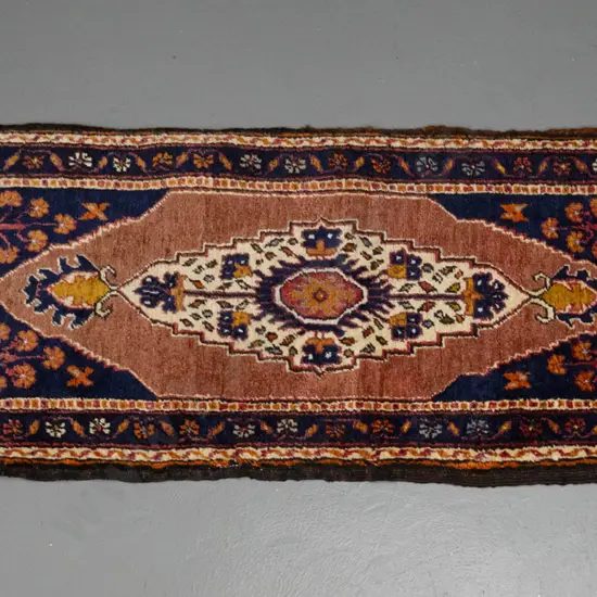 hand woven wool floor rug - dark blue, redd and oranges, fading to one end and wear to fringes L1460 W580