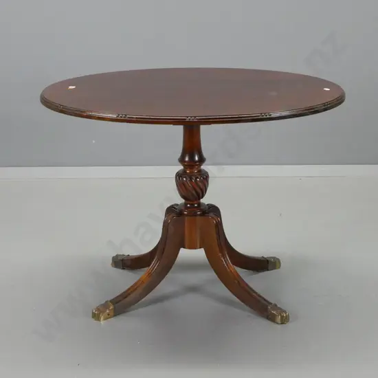 mahogany oval pedestal wine table with shaped top edge, 4 sweeping shaped legs, brass paw feet - deterioration to polish