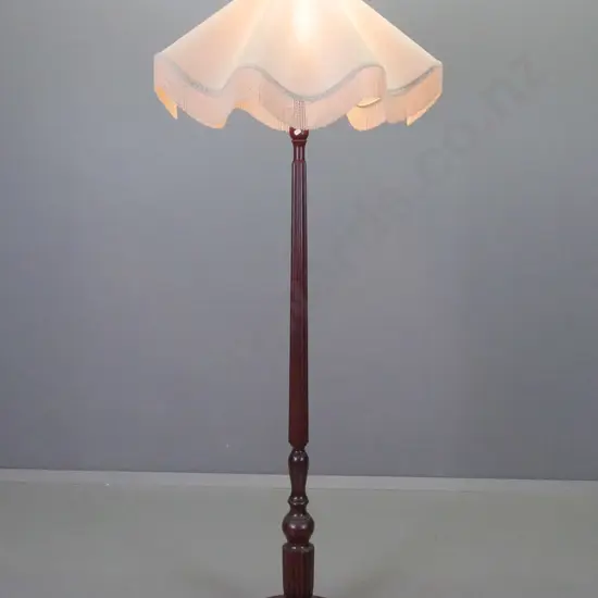 mahogany standard lamp with fluted column and turned base on 3 bun feet & scalloped edge ivory colour shade. Some stains
