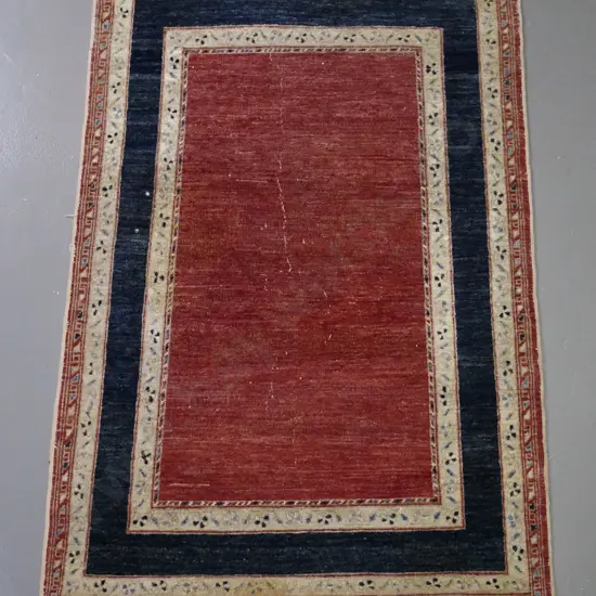 small Persian style hand knotted wool floor rug - red, blue & ivory - wear to centre and fading L-1500 W-980