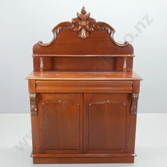 reproduction mahogany carved-back shield-door chiffonier, with key. Large shaped drawer, 2 cupboard doors, shelf to back
