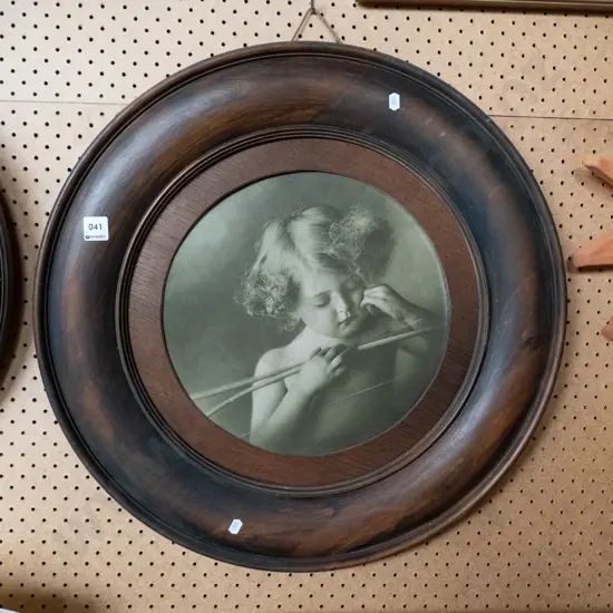 wood-framed round cupid print