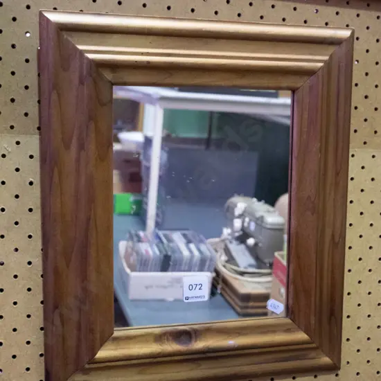 small wood-framed wall mirror