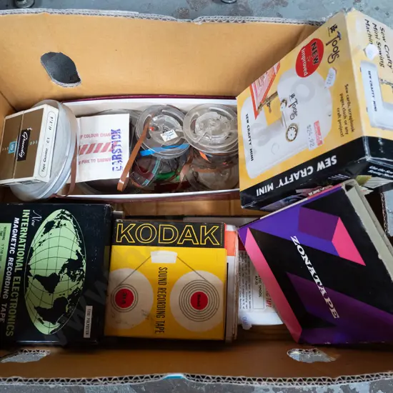 box of various 2-track tape reels and small crafter's sewing machine