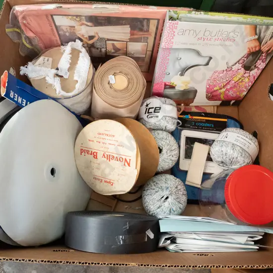box of knitting yarn, velcro, ribbon, pattern book etc.